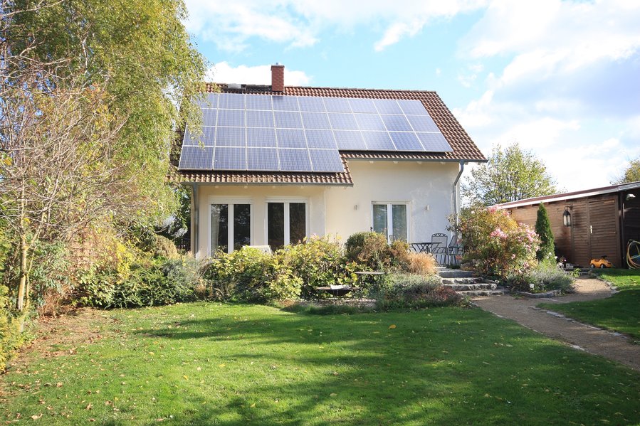 Einfamilienhaus mit Photovoltaikanlage auf parkähnlichem Grundstück mit Blick auf Felder und Wiesen